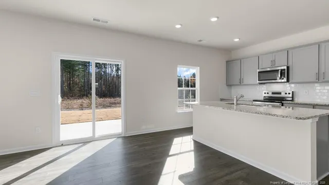 a kitchen with stainless steel appliances granite countertop a stove a sink and a refrigerator