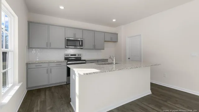 a kitchen with stainless steel appliances granite countertop a sink and a stove top oven