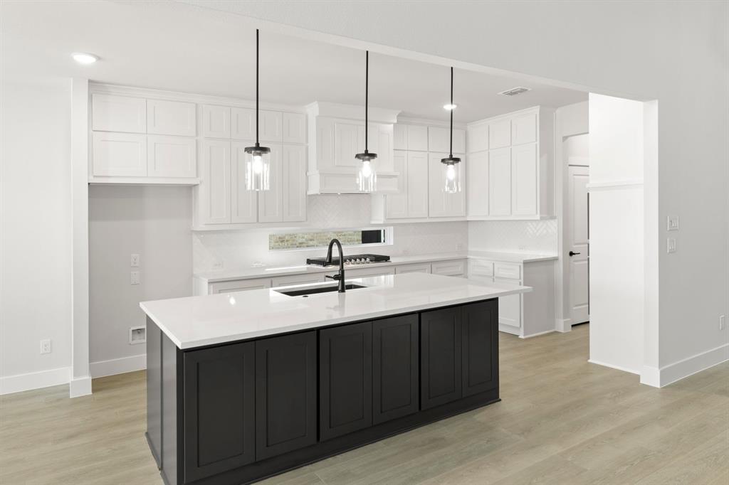a kitchen with kitchen island white cabinets appliances and a sink