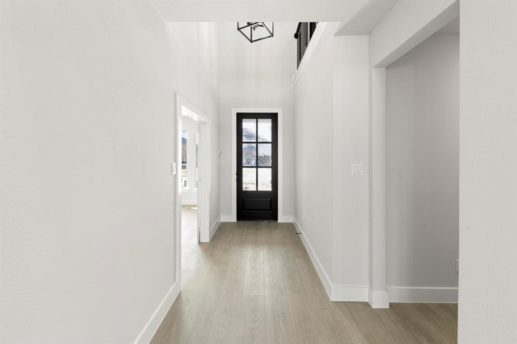 13709 Riola Drive Little Elm, TX 75068 - Photo 11 of 40 a view of a hallway with wooden floor and a bathroom