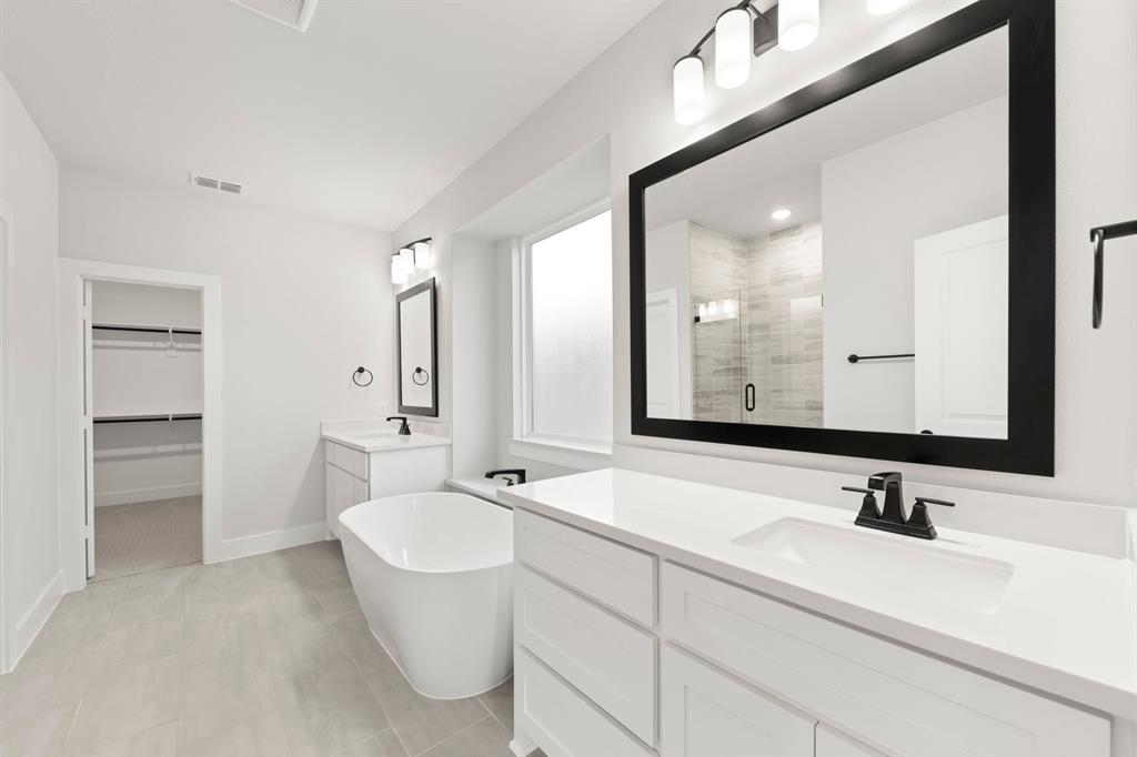 13709 Riola Drive Little Elm, TX 75068 - Photo 19 of 40 a bathroom with a double vanity sink and mirror with toilet