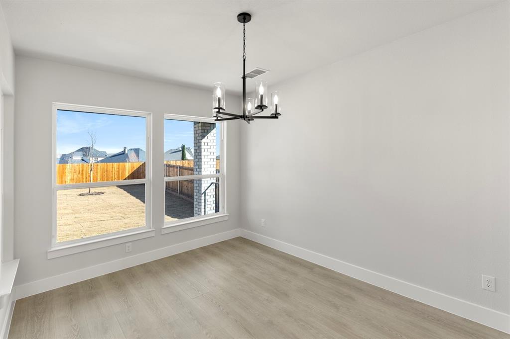 13709 Riola Drive Little Elm, TX 75068 - Photo 21 of 40 an empty room with a window and chandelier
