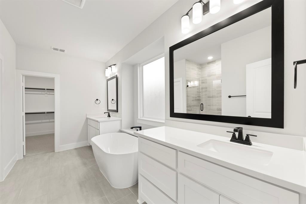 13709 Riola Drive Little Elm, TX 75068 - Photo 30 of 40 a bathroom with a double vanity sink and mirror with toilet