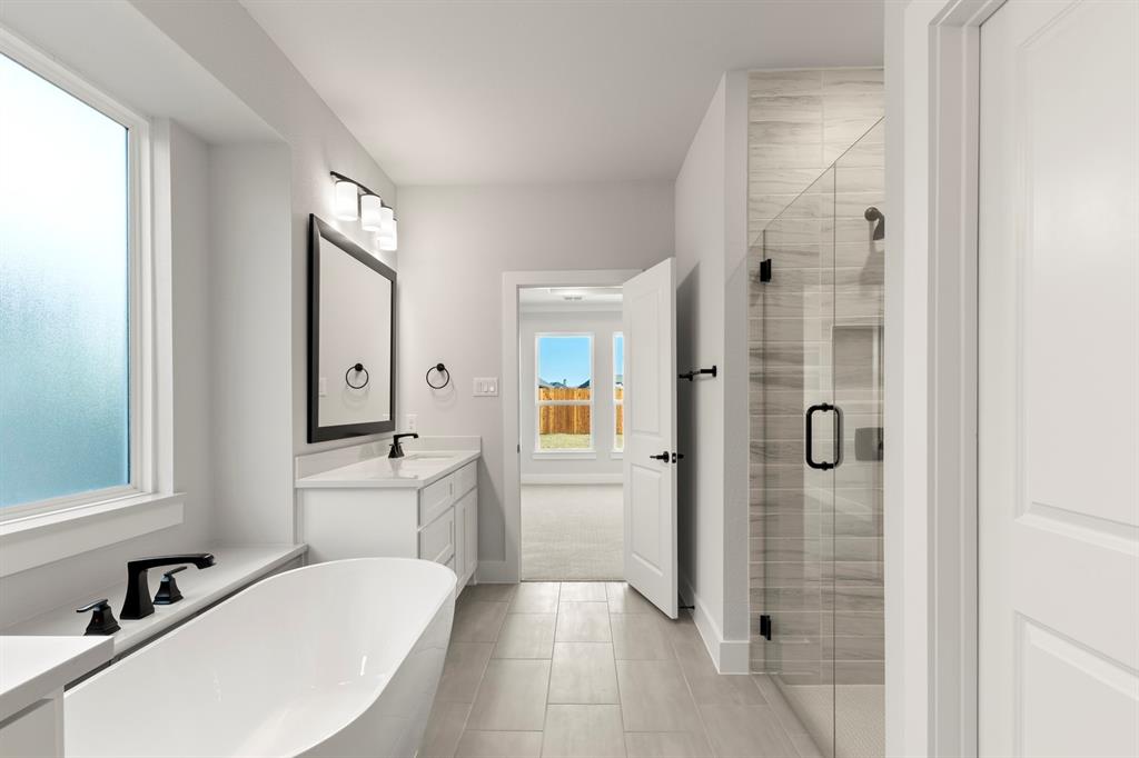 13709 Riola Drive Little Elm, TX 75068 - Photo 32 of 40 a bathroom with a sink a mirror and shower