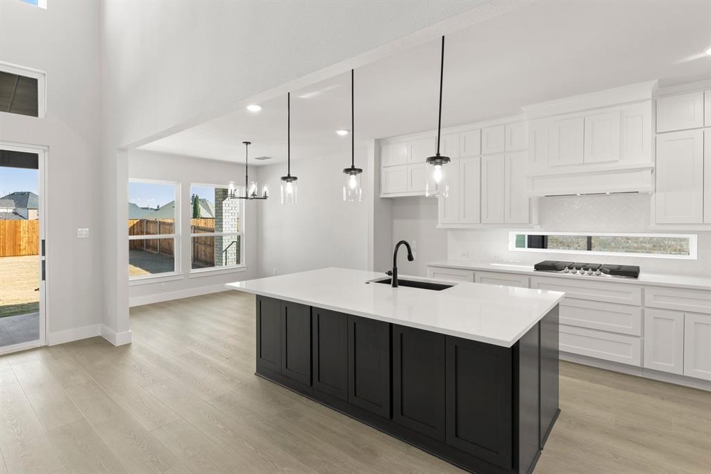 13709 Riola Drive Little Elm, TX 75068 - Photo 4 of 40 a kitchen with a sink a stove a refrigerator and white cabinets
