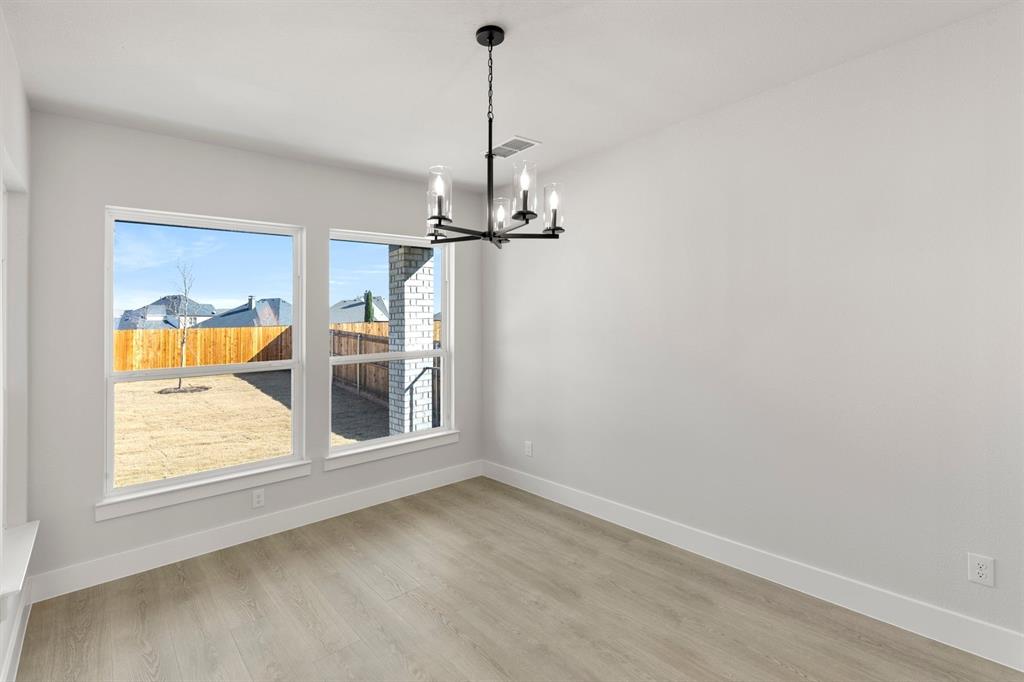 13709 Riola Drive Little Elm, TX 75068 - Photo 7 of 40 an empty room with a window and chandelier