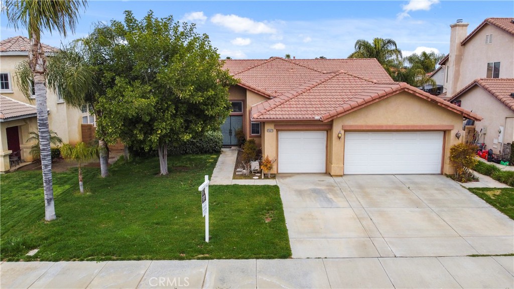 a front view of a house with a garden and plants