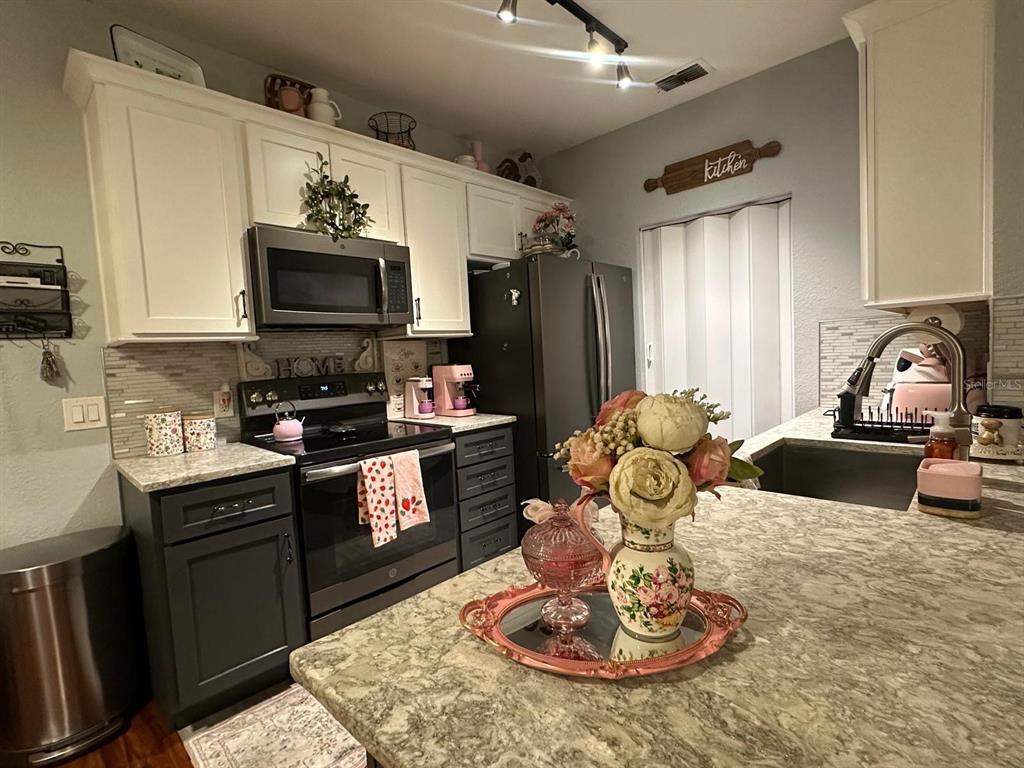 a kitchen with a refrigerator and a stove top oven