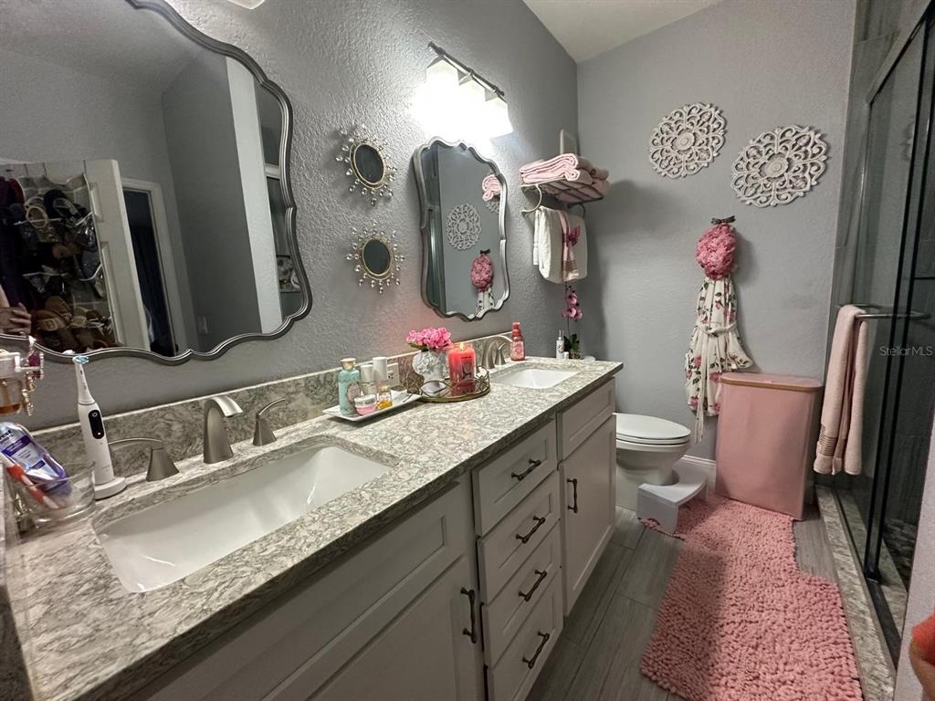 875 Grand Regency Pointe, Unit 203 Altamonte Springs, FL 32714 - Photo 6 of 17 a bathroom with a granite countertop sink a large mirror and a shower