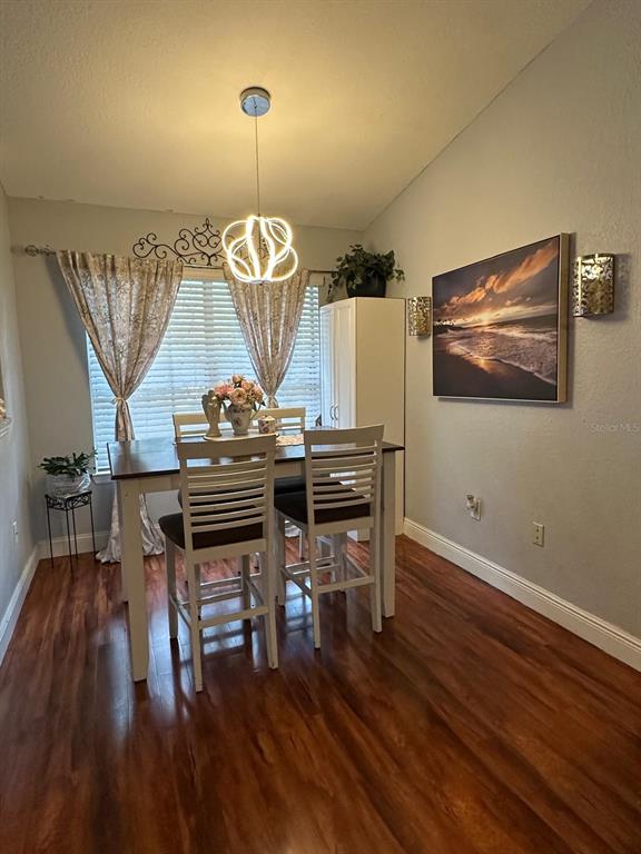 875 Grand Regency Pointe, Unit 203 Altamonte Springs, FL 32714 - Photo 8 of 17 a view of a dining room with furniture wooden floor and chandelier