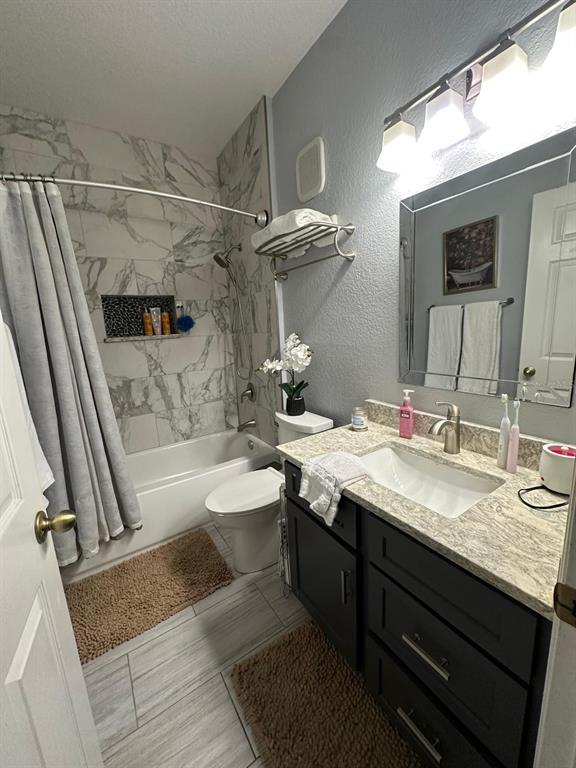 875 Grand Regency Pointe, Unit 203 Altamonte Springs, FL 32714 - Photo 10 of 17 a bathroom with a granite countertop sink a toilet a mirror and bathtub
