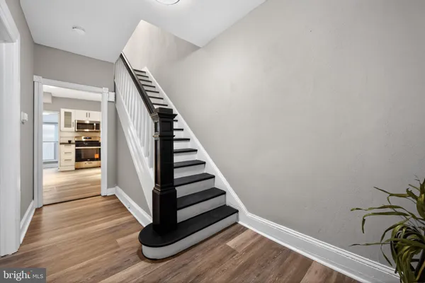 a view of a hallway with wooden floor and staircase