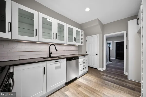 a kitchen with granite countertop white cabinets and sink