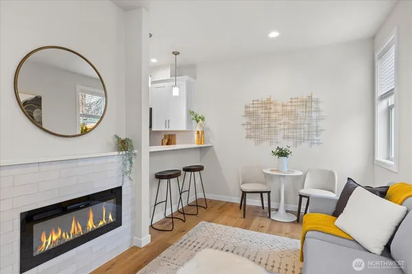 a living room with furniture a fireplace and a large window