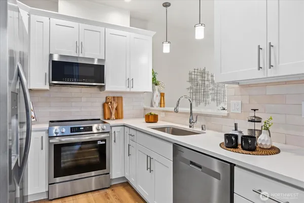 a kitchen with stainless steel appliances white cabinets and a stove a oven with white countertops