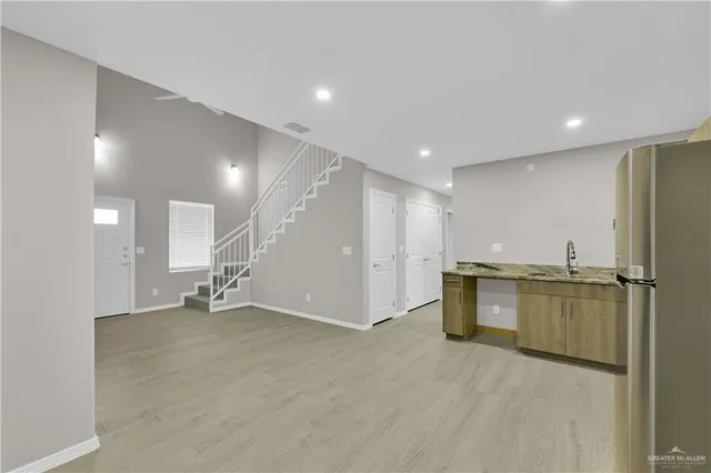 a view of a kitchen with a sink and a refrigerator