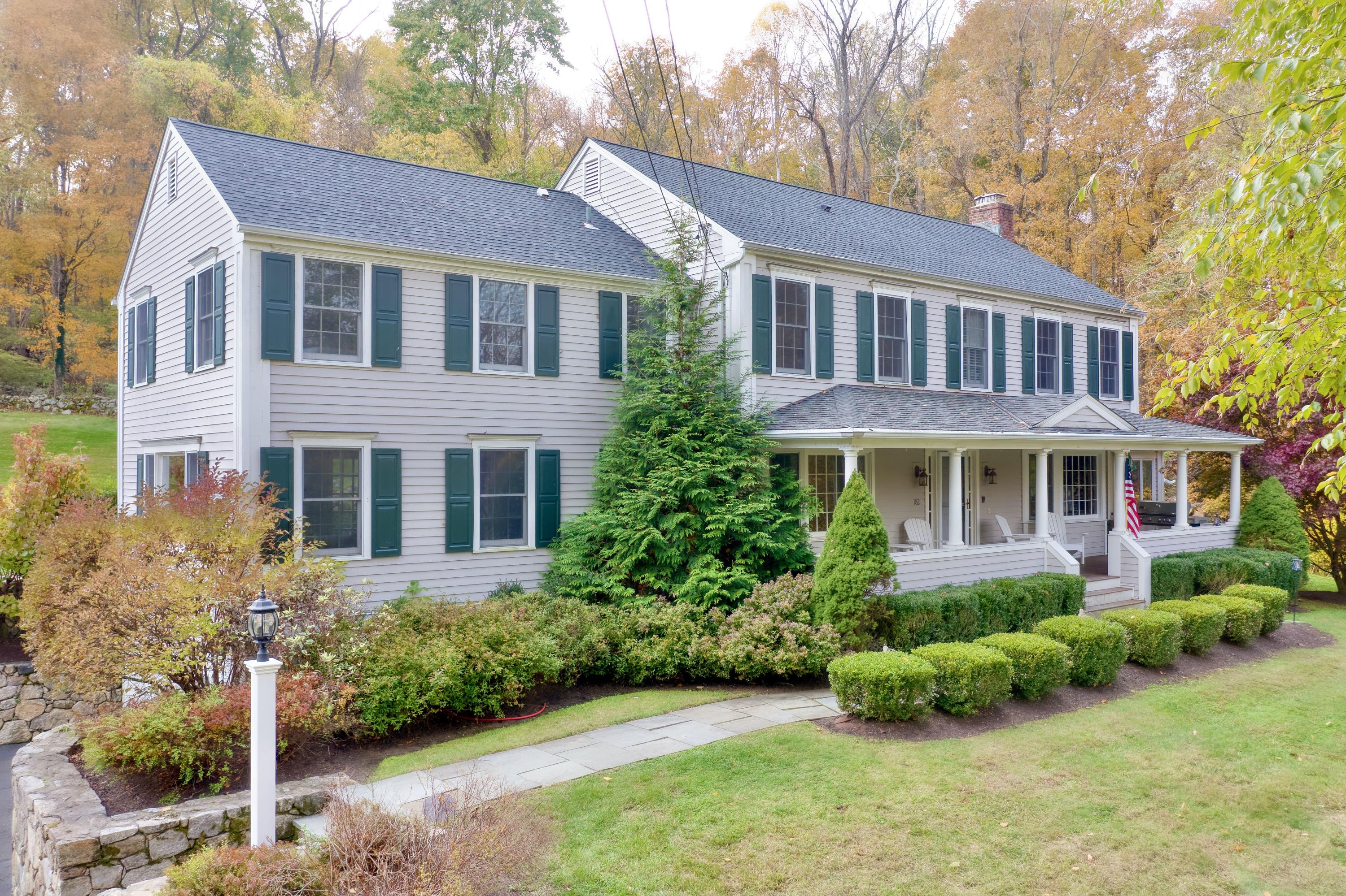 182 Deep Valley Road New Canaan, CT 06840 - Photo 23 of 34 a front view of a house with a yard and trees