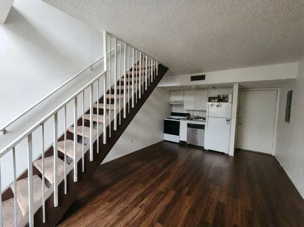 a view of staircase and kitchen with wooden floor