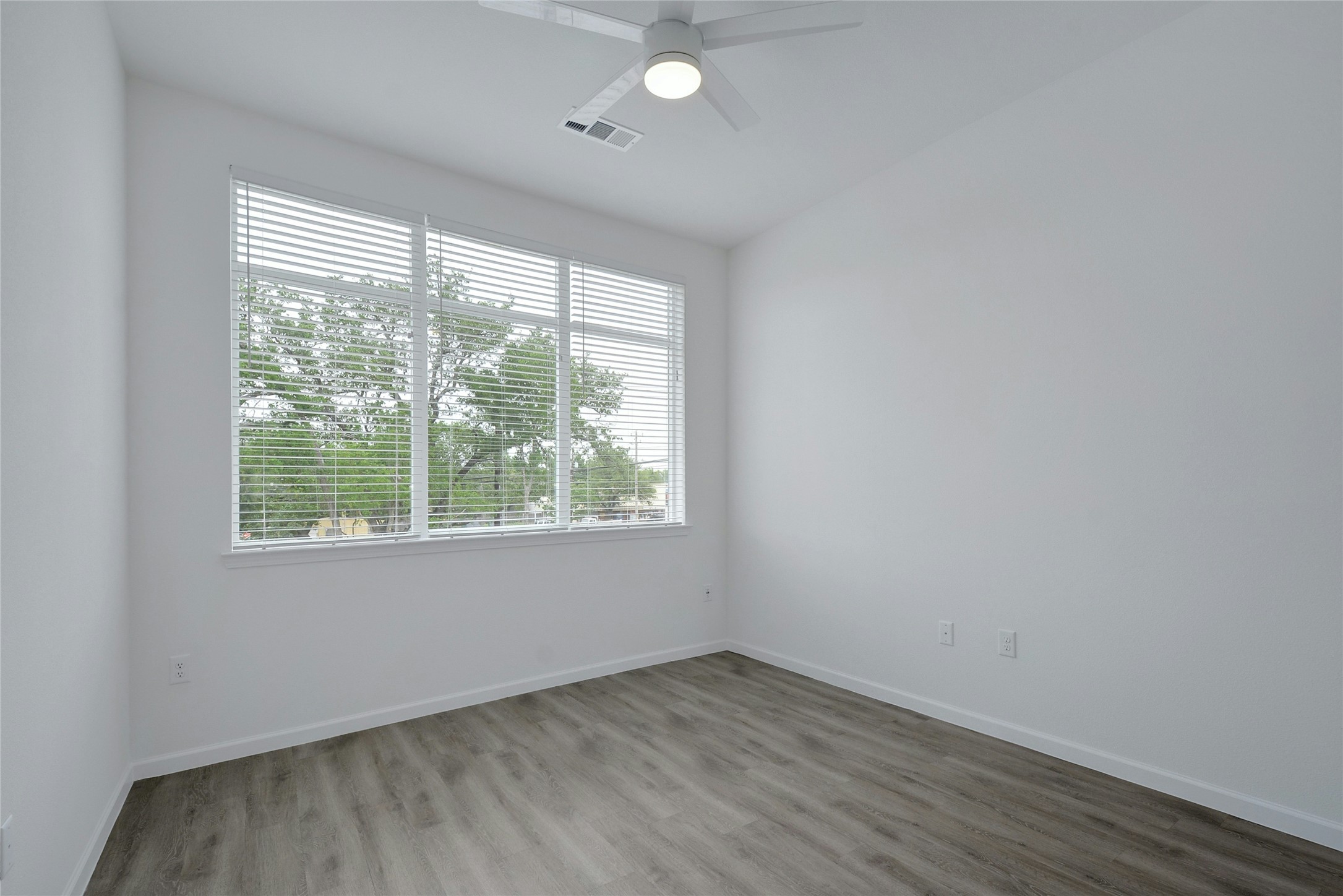 13130 Pond Springs Road, Unit 1105 Austin, TX 78729 - Photo 20 of 22 an empty room with wooden floor and windows