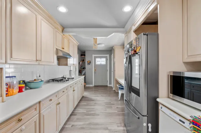 a kitchen with stainless steel appliances granite countertop a refrigerator and a stove