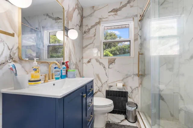 a bathroom with a sink vanity mirror and toilet