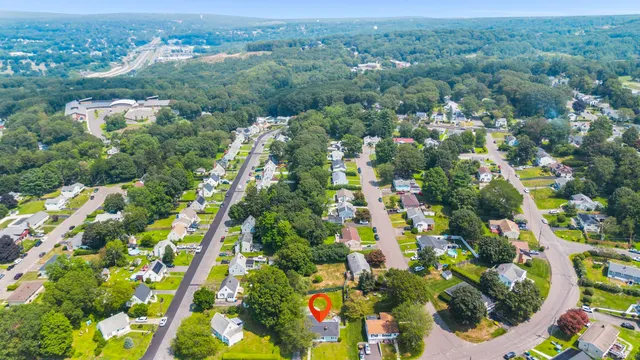 an aerial view of residential houses with outdoor space and trees