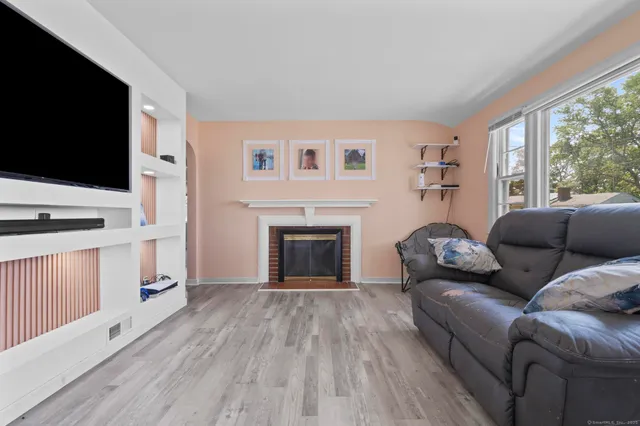 a living room with furniture a flat screen tv and a fireplace