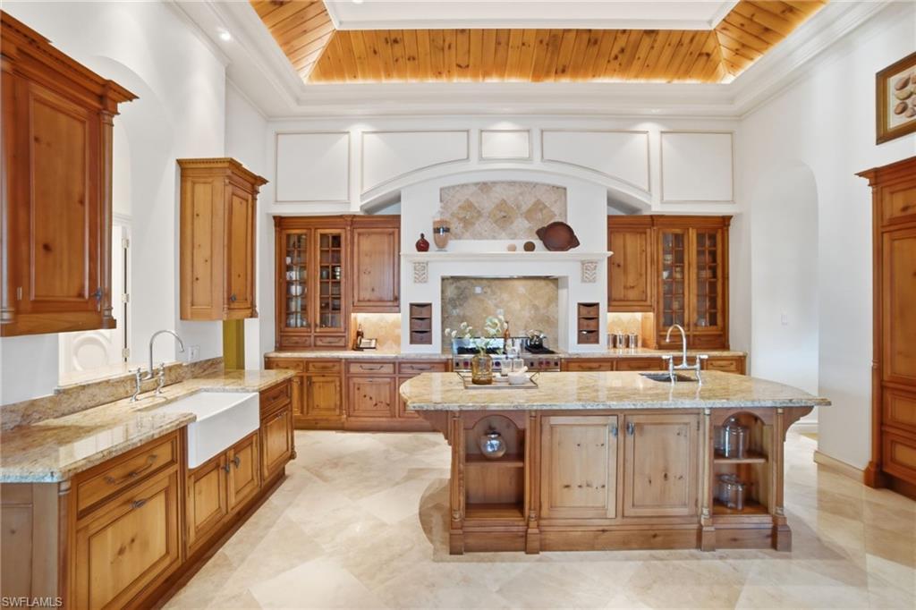 28920 Cavell Terrace Naples, FL 34119 - Photo 20 of 50 a large kitchen with a stove a kitchen island a sink and a large window