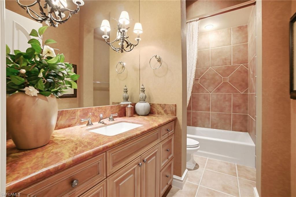 28920 Cavell Terrace Naples, FL 34119 - Photo 25 of 50 a bathroom with a granite countertop sink a mirror and a shower