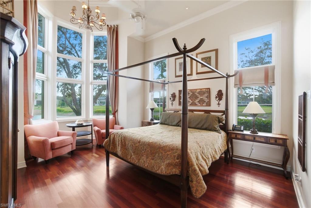 28920 Cavell Terrace Naples, FL 34119 - Photo 32 of 50 a bedroom with a bed couch and a large window with wooden floor