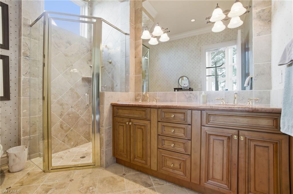 28920 Cavell Terrace Naples, FL 34119 - Photo 33 of 50 a bathroom with a granite countertop sink a mirror and a shower
