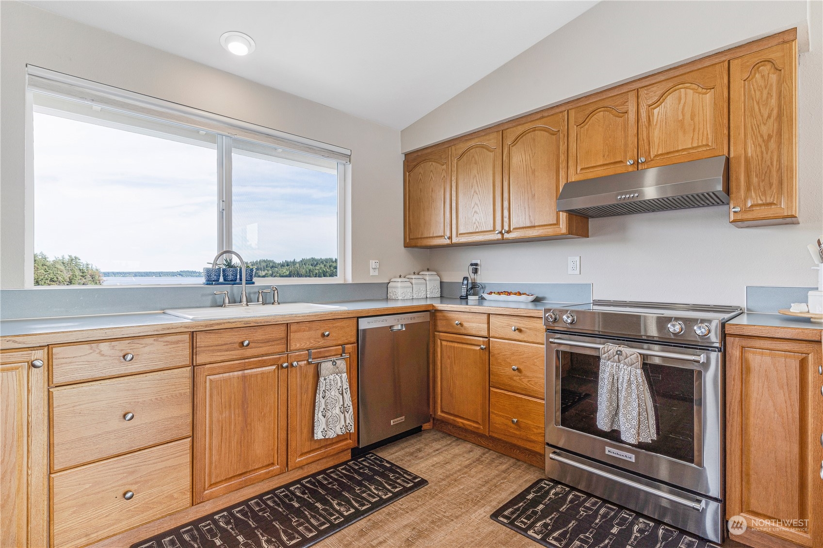 2942 Steamboat Island Road Northwest Olympia, WA 98502 - Photo 14 of 40 a kitchen with stainless steel appliances granite countertop a stove a sink and a microwave