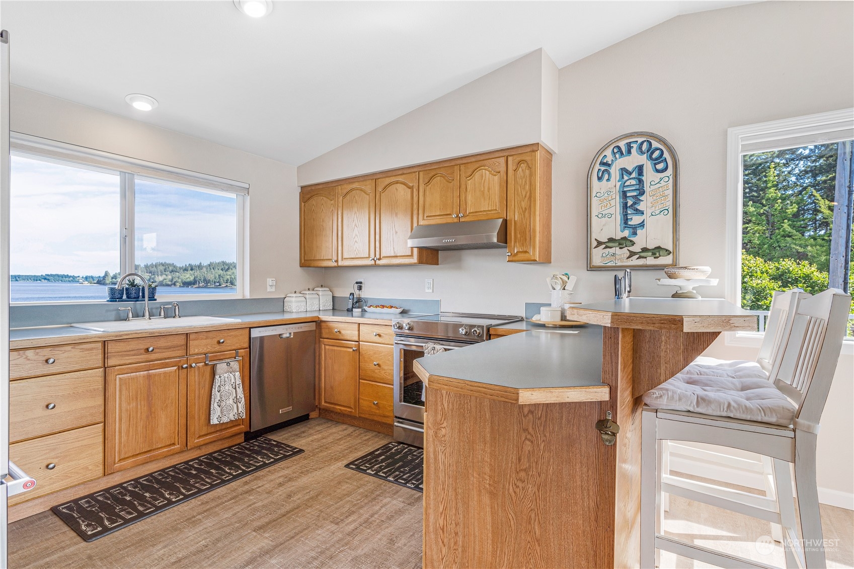 2942 Steamboat Island Road Northwest Olympia, WA 98502 - Photo 17 of 40 a kitchen with stainless steel appliances granite countertop a sink cabinets and wooden floor
