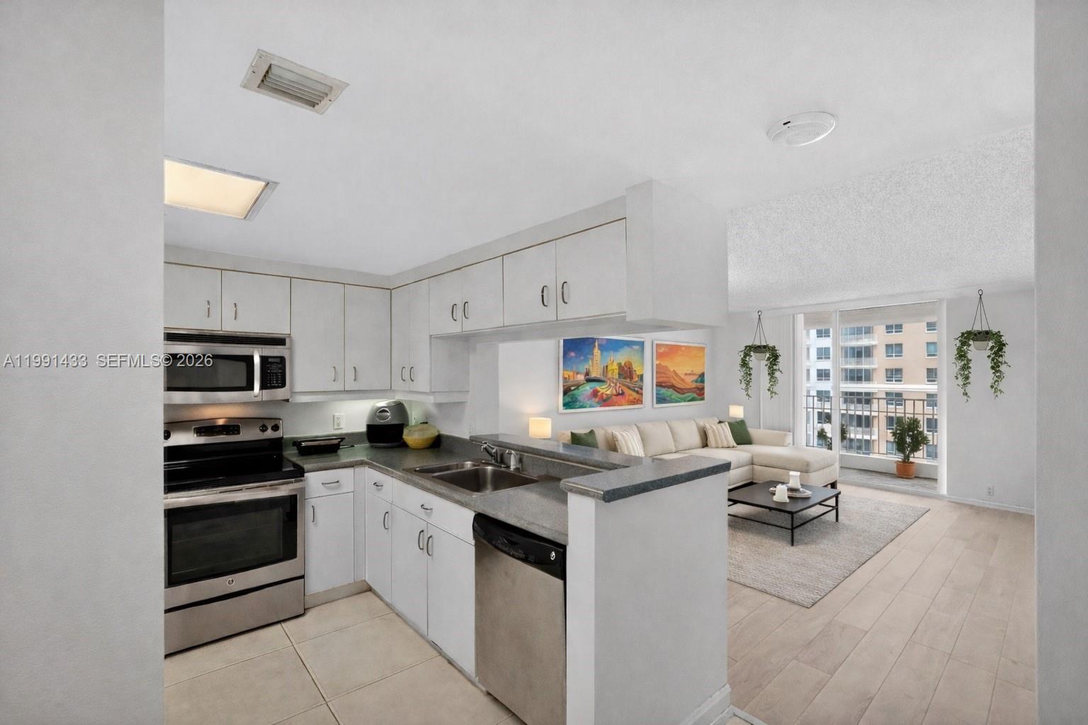 701 Brickell Key Boulevard, Unit 1108 Miami, FL 33131 - Photo 5 of 13 a kitchen with stainless steel appliances a stove a sink and a refrigerator