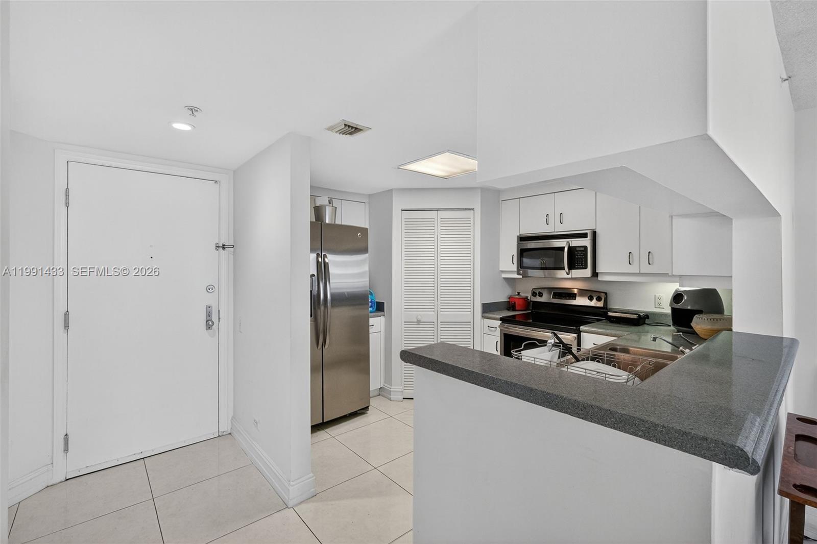 701 Brickell Key Boulevard, Unit 1108 Miami, FL 33131 - Photo 6 of 13 a kitchen with stainless steel appliances a stove a sink a refrigerator a microwave and cabinets