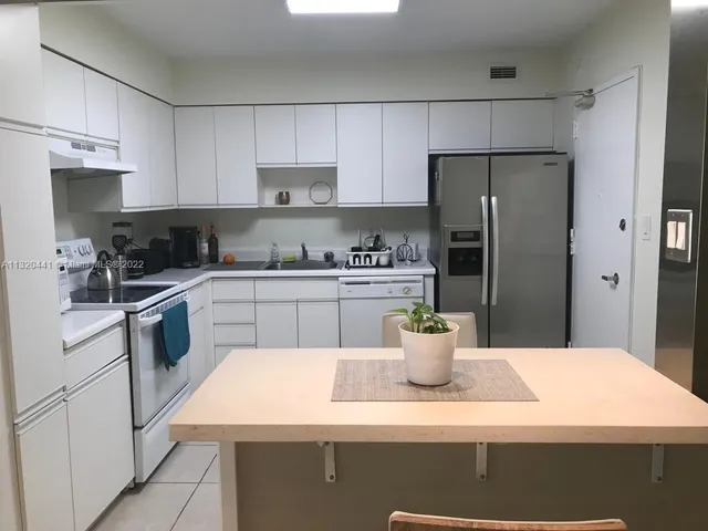 a kitchen with a sink a refrigerator a stove and cabinets