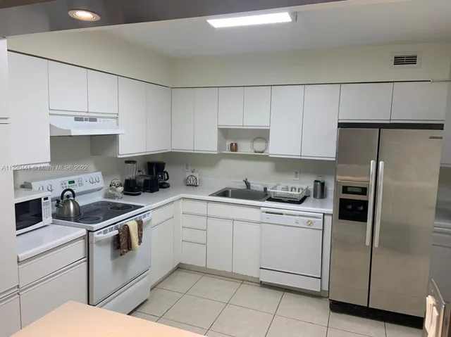 a kitchen with cabinets stainless steel appliances and a sink