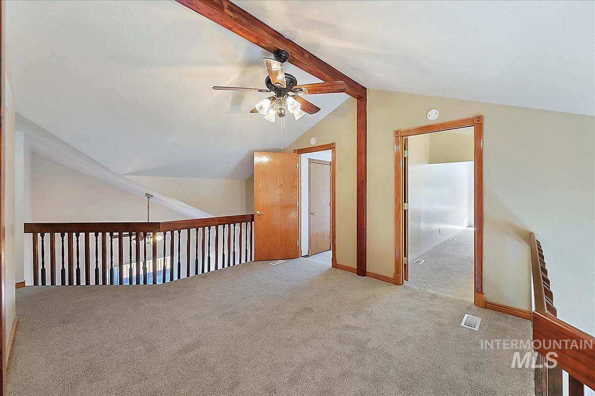 2804 West Sunrise Rim Road Boise, ID 83705 - Photo 32 of 50 Carpeted loft space featuring an angled ceiling with exposed wood beams, a ceiling fan with integrated lighting, and open doorways to additional rooms