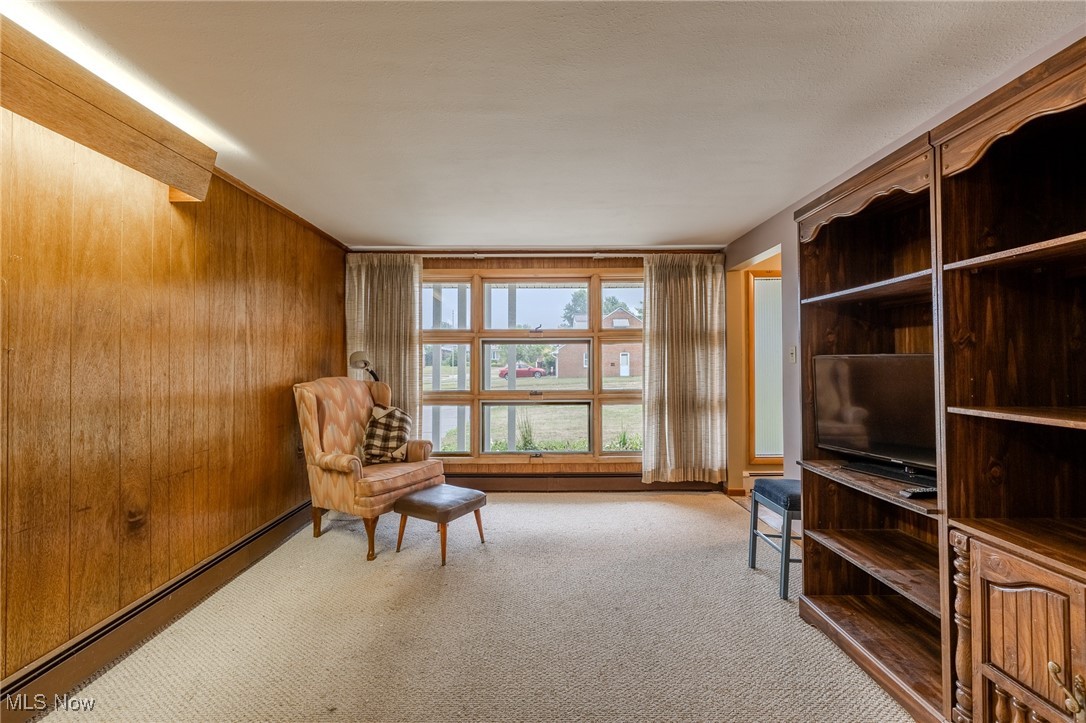1950 Rush Road Wickliffe, OH 44092 - Photo 47 of 50 Living area featuring baseboard heating, light colored carpet, and wooden walls
