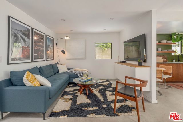 a living room with furniture wooden floor and a flat screen tv