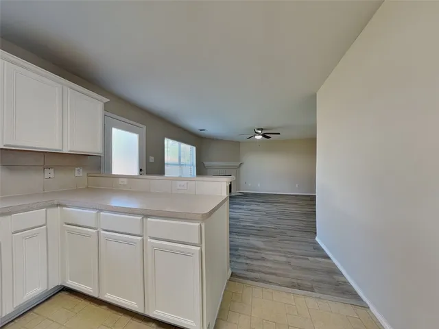 a view of a kitchen with white cabinets