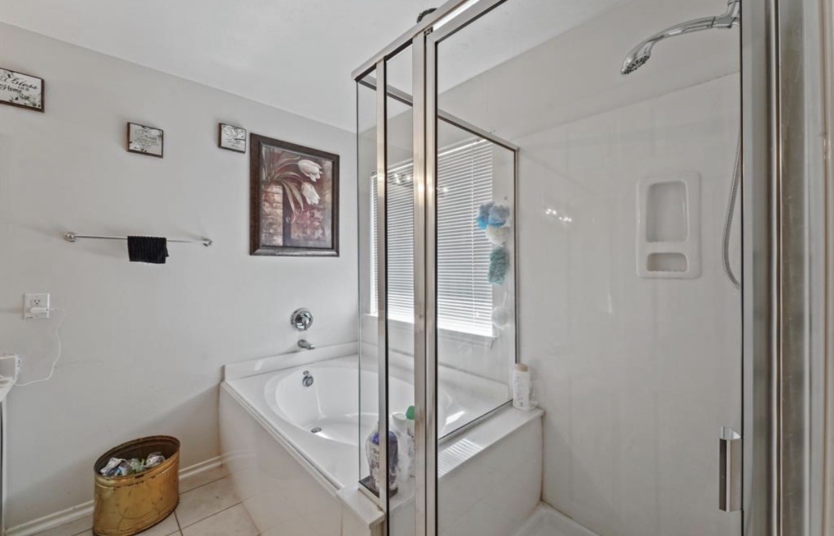 13134 Peppergate Lane Houston, TX 77044 - Photo 17 of 23 a bathroom with a tub and a shower