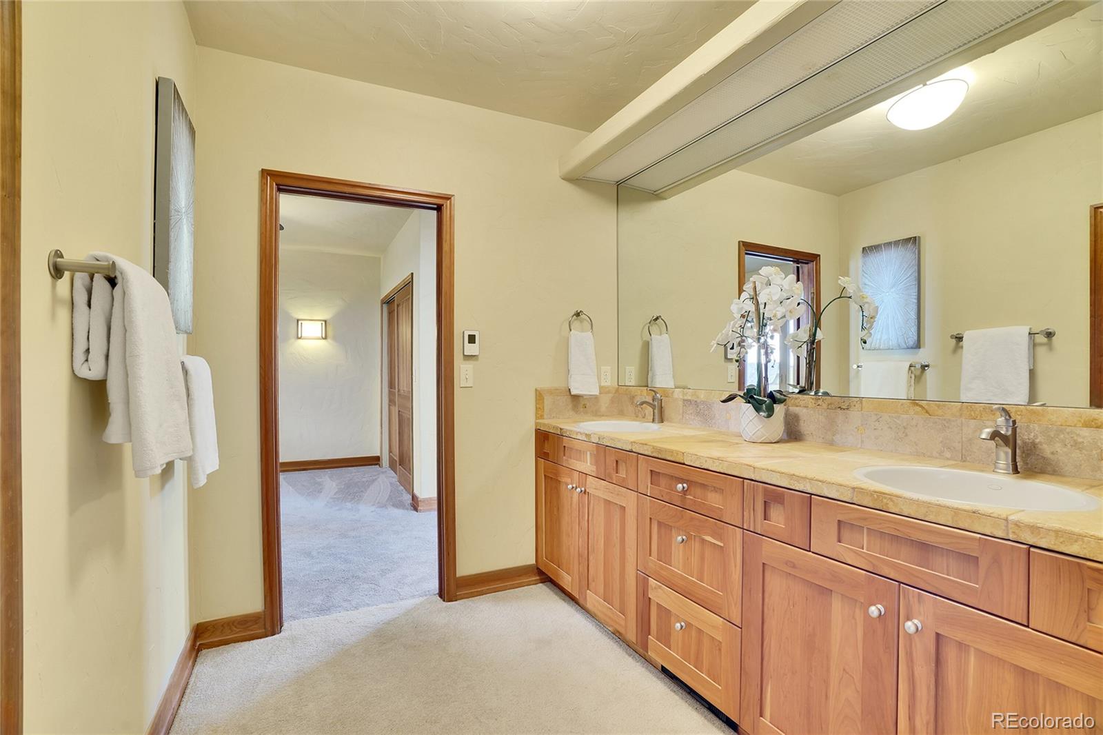 6057 Red Hill Road Boulder, CO 80302 - Photo 24 of 41 a spacious bathroom with a double vanity sink a mirror and a shower