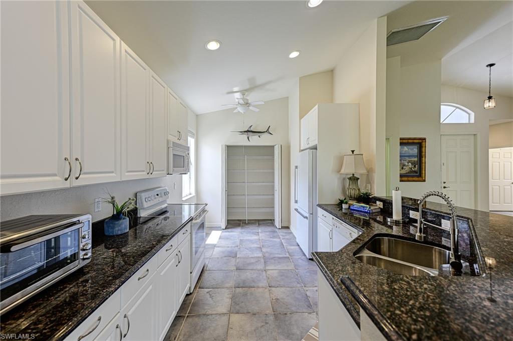 9290 Springview Loop Estero, FL 33928 - Photo 7 of 25 a kitchen with granite countertop a sink and cabinets