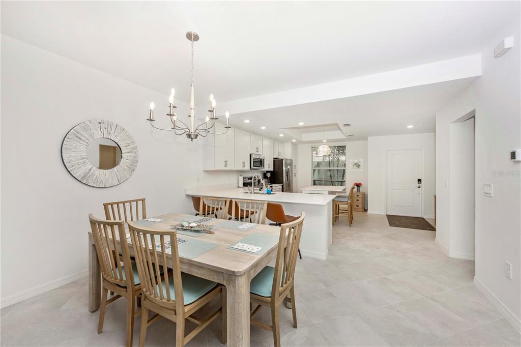17500 Opal Sand Drive, Unit 101 Venice, FL 34293 - Photo 13 of 98 a view of a dining room with furniture and a chandelier
