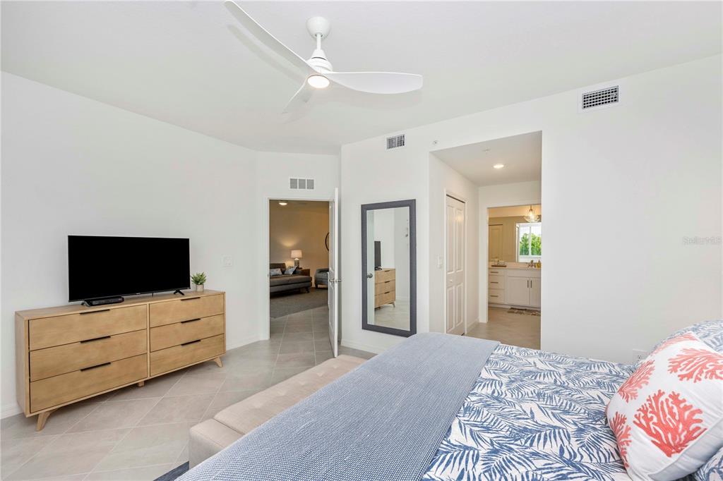 17500 Opal Sand Drive, Unit 101 Venice, FL 34293 - Photo 28 of 98 a bedroom with furniture and flat screen tv