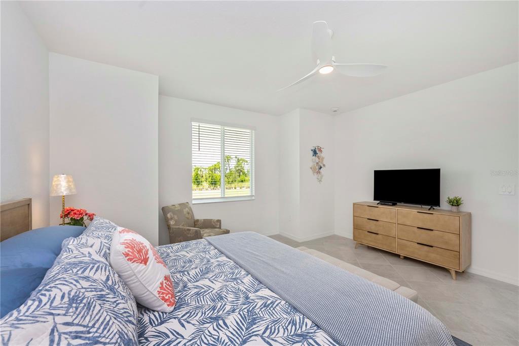 17500 Opal Sand Drive, Unit 101 Venice, FL 34293 - Photo 29 of 98 a bedroom with a bed and a flat screen tv