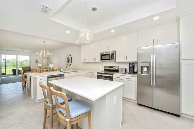 a kitchen with a dining table chairs and white cabinets