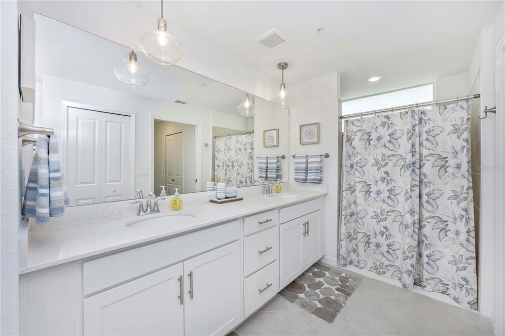 17500 Opal Sand Drive, Unit 101 Venice, FL 34293 - Photo 32 of 98 a bathroom with a double vanity sink mirror and shower