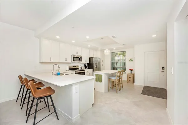 a kitchen with a sink a counter top space stainless steel appliances and cabinets
